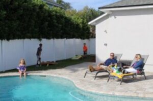 Family relaxing by the pool and in their backyard